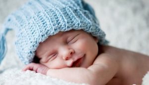 Sovande bebis med mössa