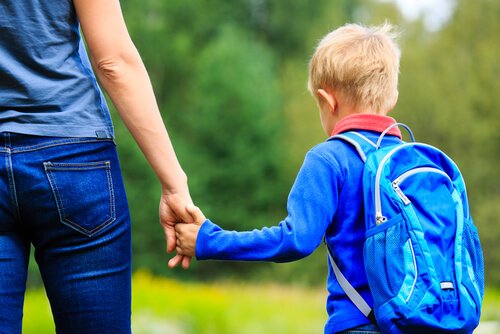 Mor och pojke går till skolan