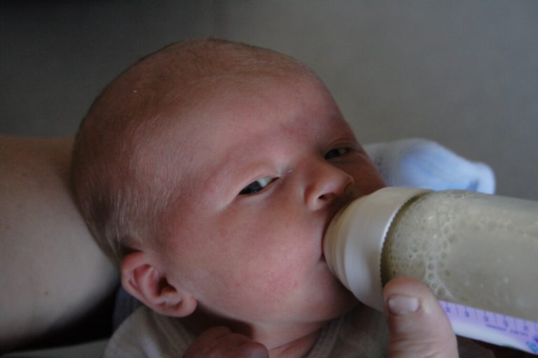 Bebis äter från flaska