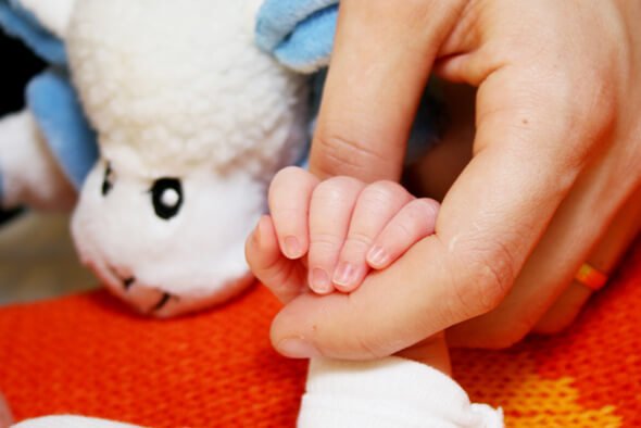 Mor som håller en liten hand