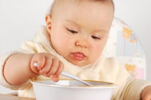 Bebis äter med sked