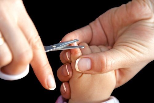 Mor som klipper barns naglar.