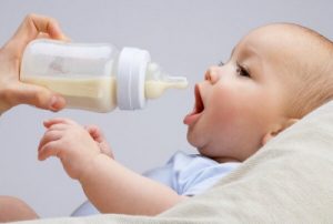 ett spädbarn som dricker från nappflaska