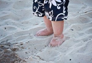 Barfota barn på strand