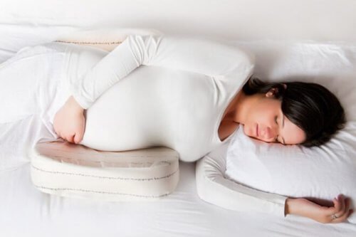 Gravid kvinna sover på kudde