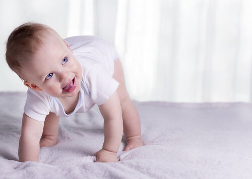 Barn som försöker resa sig på säng.