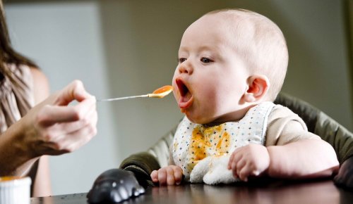 Bebis som äter från sked.