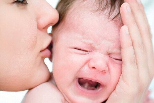 En mamma tröstar sin skrikande bebis.