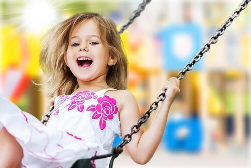 Glad flicka på gunga
