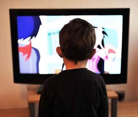 Pojke framför tv: ser om samma film