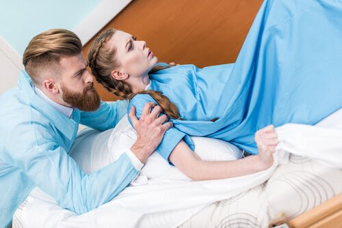 Man håller om axlarna på kvinna med ambulatorisk epiduralbedövning