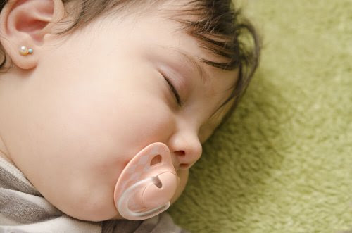 Bebis sover med napp i munnen