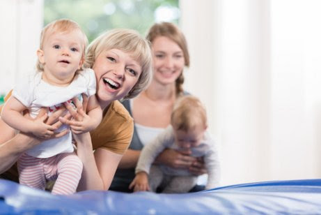 Mammor leker med bebisar på babygym