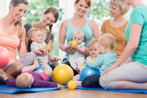Mammor och bebisar på mattor med bollar