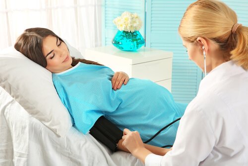 Kvinna tas om hand inför förlossningen.