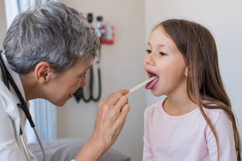 doktor undersöker tungan på flicka