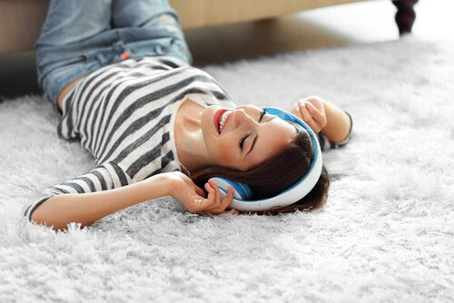 Tonåring ligger på golvet och lyssnar på musik