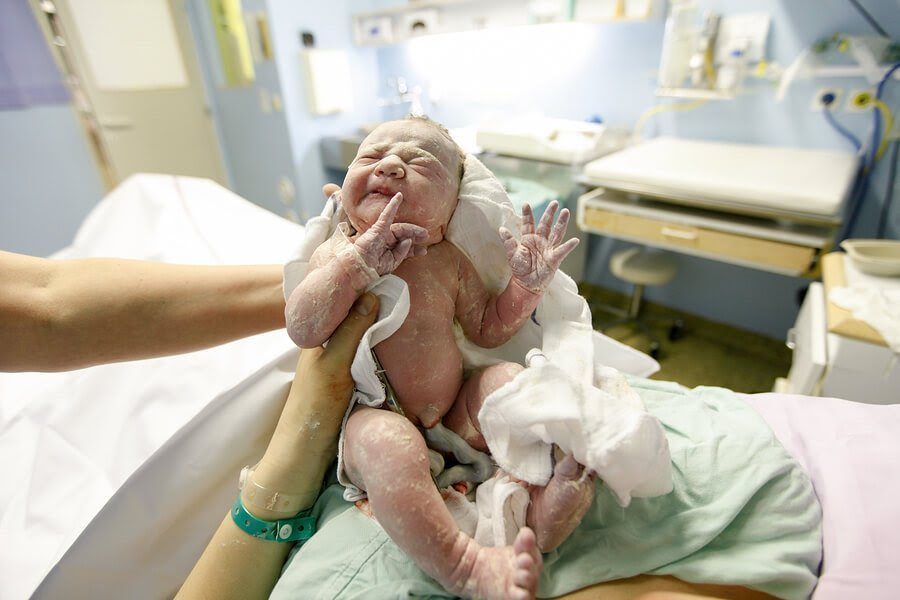 nyfödd bebis med navelsträngen kvar
