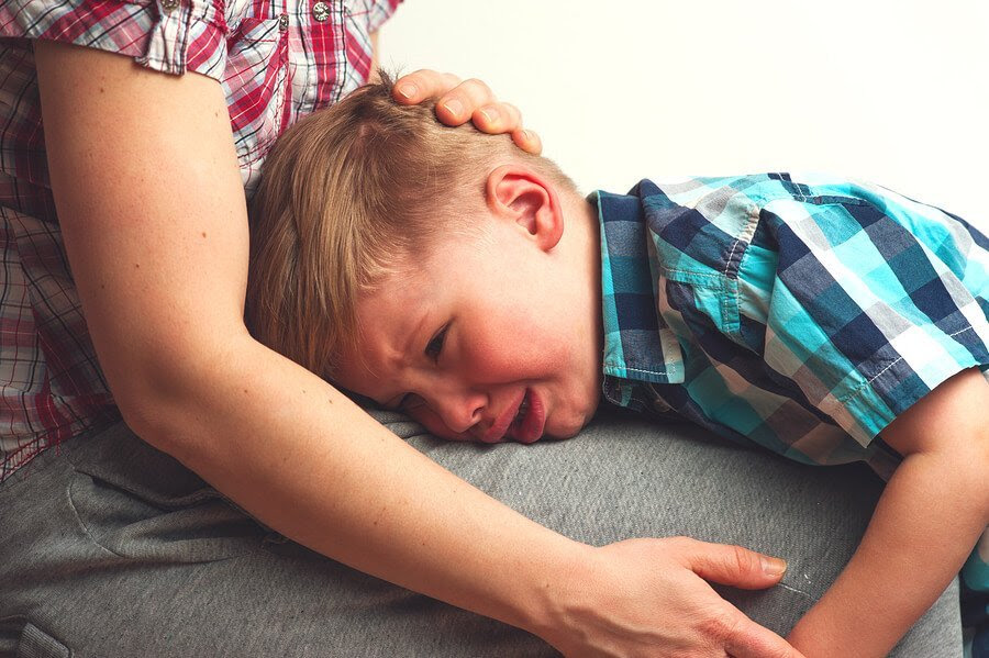pojke gråter i sin mammas knä