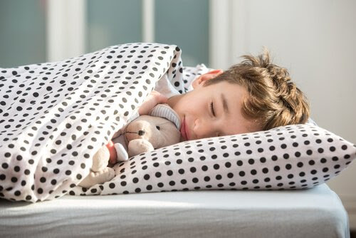 barn sover i säng med nalle
