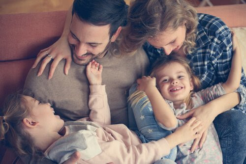 Mamma, pappa och två barn gosar