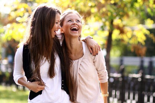 Två kvinnor håller om varandra och skrattar