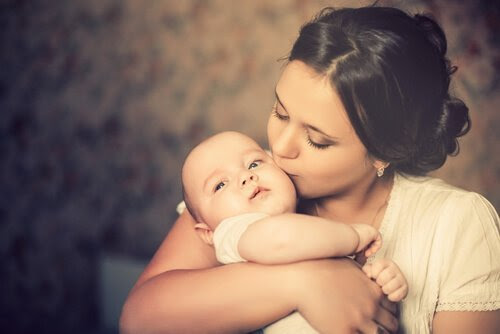 en mammas kärlek: mamma kysser spädbarn