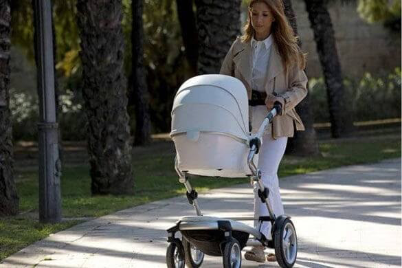 kvinna går med barnvagn
