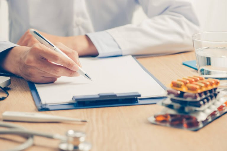 läkare med skrivblock och läkemedel