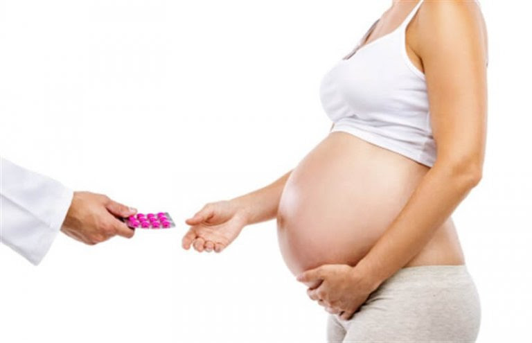gravid kvinna tar emot medicin från en läkare
