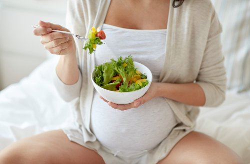 En gravid kvinna äter sallad.