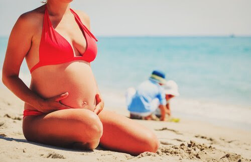 7 tips för gravida kvinnor på sommaren: gravid kvinna i bikini på stranden