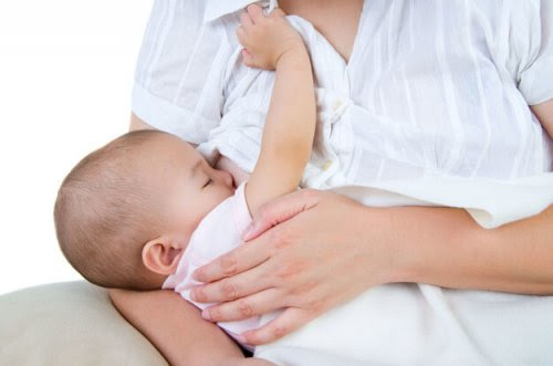 Mastit och probiotika: En effektiv allians: kvinna ammar spädbarn