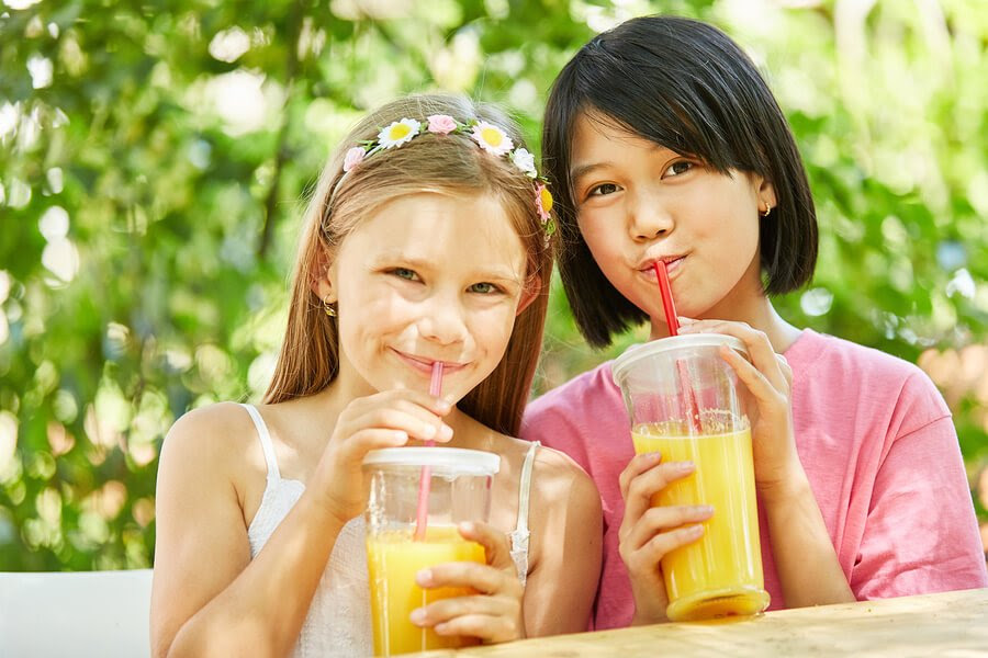Två flickor dricker juice