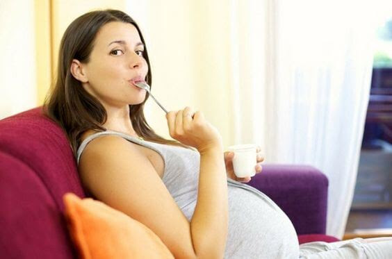 gravid kvinna äter med sked