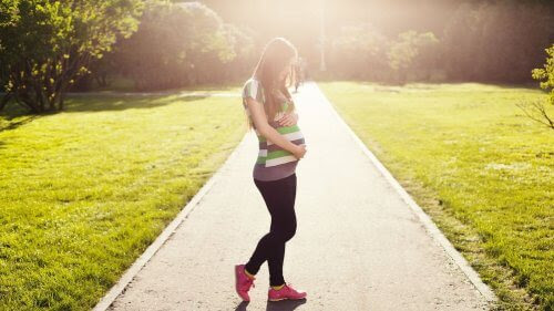 gravid kvinna på promenad i motljus