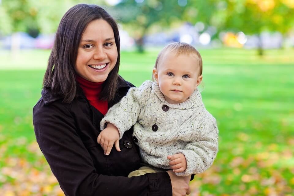 Mamma med bebis i park