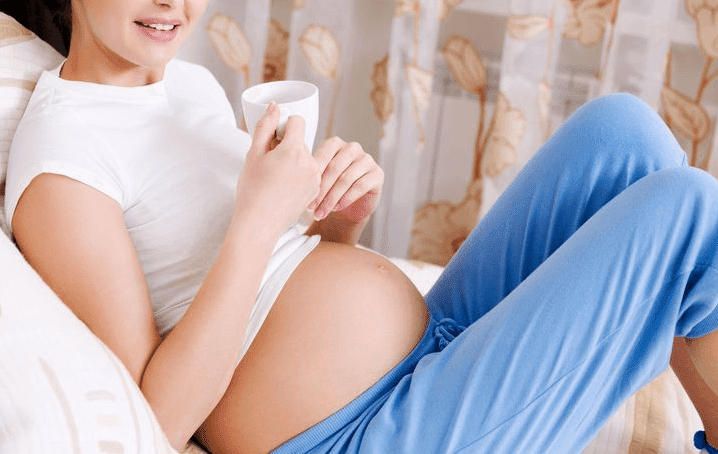 gravid kvinna med tekopp