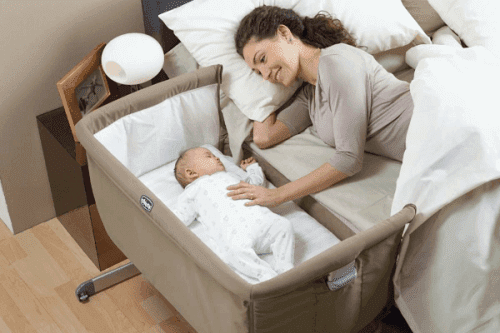 En mamma med sin bebis i en "sidosäng".
