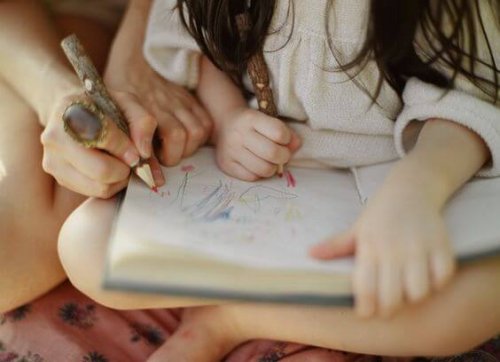 Ett barn ritar tillsammans med en vuxen.