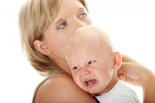 Kvinna bär gråtande bebis