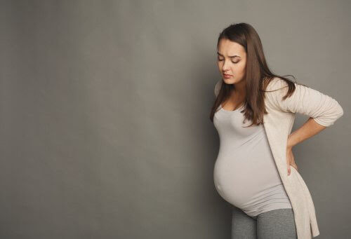 Gravid kvinna håller sig för ryggen