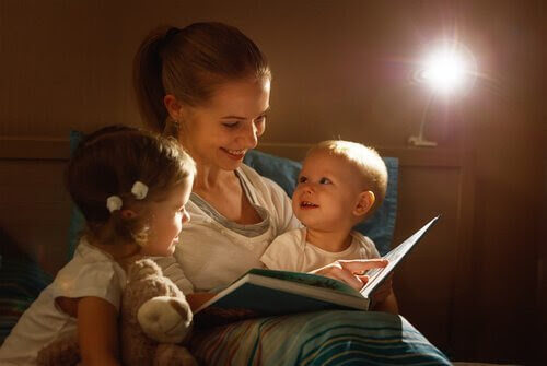 mamma läser godnattsaga för två små barn
