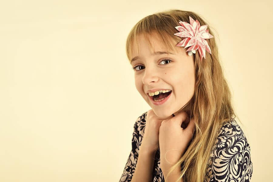 leende flicka med blomma i håret