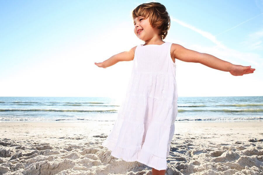 flicka i vit klänning på strand