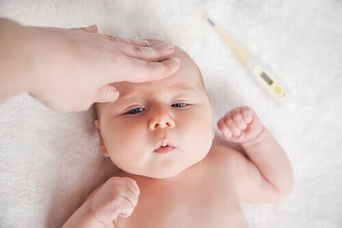 Tricks för att sänka feber på spädbarn: spädbarn med någon som känner på pannan samt bredvid febertermometer