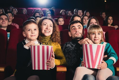 Familj i biosalong med popcorn