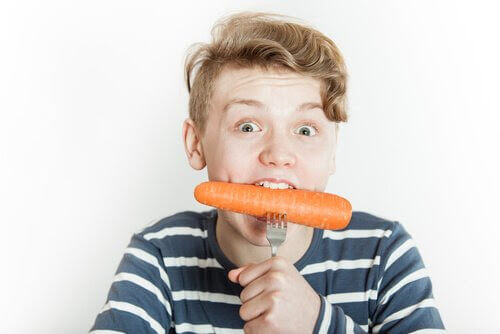 Pojke äter morot på gaffel