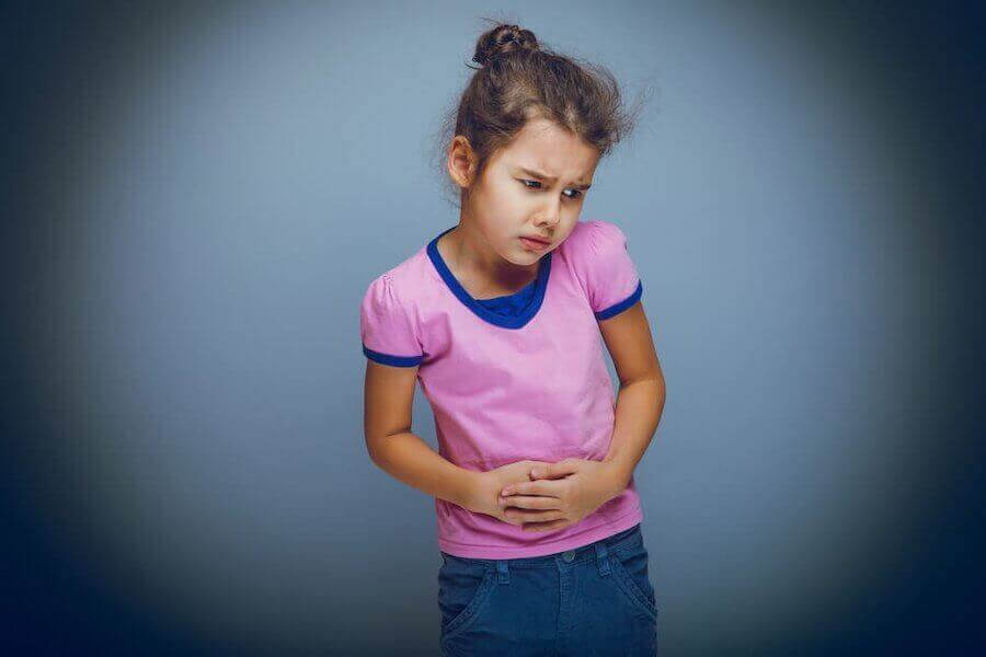 Funktionell buksmärta hos barn: flicka håller sig för magen