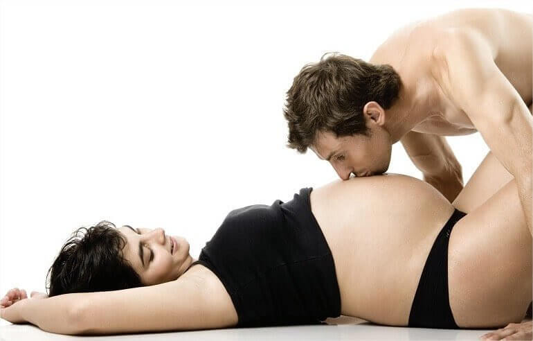 man kysser gravid kvinnas mage